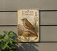 a metal sign with a bird illustration, mounted on a wall next to a plant.