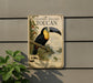 a vintage-style metal sign with a detailed illustration of a toucan perched on a branch, surrounded by lush foliage.