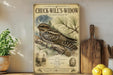 A framed illustration of a woodpecker, labeled as "CHUCK-WILL'S-WIDOW", is displayed on a shelf next to a wooden cutting board and a potted plant.