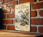 A vintage-style metal sign with a detailed illustration of a nutcracker bird, mounted on a brick wall.