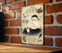 a vintage-style metal sign with illustrations of ducks and other wildlife, mounted on a brick wall.