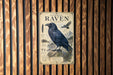 a poster of a raven, which is mounted on a wooden wall.
