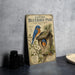 a vintage-style poster or artwork of a bluebird perched on a birdhouse, surrounded by flowers and leaves, with a text overlay that reads "Eastern Bluebird Pair at Nest Box".