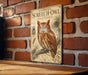 a vintage-style poster of an Eastern Screech- Owl, mounted on a brick wall.