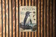 a poster of a penguin on a wooden wall.