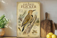 a framed illustration of a gilded flicker, a type of bird, perched on a tree branch. The flicker is depicted in a detailed and realistic manner, showcasing its distinctive markings and features. The framed artwork is displayed on a shelf, surrounded by various kitchen utensils and decor items, such as a potted plant, a cutting board, and a bowl of fruit.