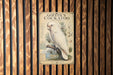 A vintage-style illustration of a white cockatoo perched on a branch, with text providing information about the bird.