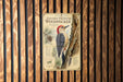 a vintage-style poster of a golden-fronted woodpecker, mounted on a wooden wall.