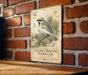 A vintage-style metal sign featuring a detailed illustration of a golden-winged warbler perched on a branch, with various botanical illustrations and text.