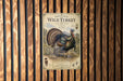 A vintage-style poster of a wild turkey is displayed on a wooden wall, featuring a detailed illustration of the turkey and its natural habitat.