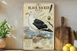 A framed illustration of a Great Black-Backed Gull, a seabird species, is displayed on a shelf next to a wooden cutting board and some potted plants.