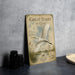 a vintage-style sign with a white heron illustration, placed on a table next to some black camera lenses.