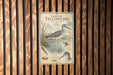 a metal sign with illustrations and text about greater yellow legs, mounted on a wooden wall.