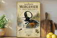 a poster of a hooded merganser, a type of duck, with a detailed illustration of the bird in a pond surrounded by plants. The poster also includes text and images related to the hooded merganser, such as its habitat, diet, and behavior.