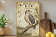 a framed illustration of a Hook-billed Kite, a bird of prey, perched on a branch. The bird is depicted in a detailed manner, showcasing its physical features and natural habitat. The framed artwork is displayed on a shelf, surrounded by various kitchen utensils and a potted plant.