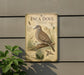 a vintage-style metal sign with an illustration of an Inca dove, mounted on a wall.