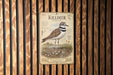 a poster of a Killdeer, a bird species, mounted on a wooden wall.
