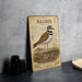A metal plaque with an illustration of a killdeer standing on a rocky shore, surrounded by text and a bird illustration.