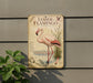 a vintage-style metal sign with a pink flamingo illustration, mounted on a wall.