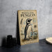 a vintage-style poster or book cover for "Maggellic penguin" with illustrations and text, placed on a gray surface next to some black camera lenses.