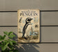 a vintage-style metal plaque with an illustration of a Magellanic penguin, mounted on a wall.