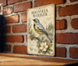 A vintage-style metal sign featuring a detailed illustration of a Magnolia Warbler, a type of bird, perched on a branch with a magnolia flower in the foreground.