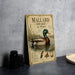 A vintage-style metal sign featuring an illustration of a mallard duck swimming on water, with additional text and decorative elements.