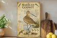 a vintage-style poster of a coastal sanderau, a type of wading bird, displayed on a shelf next to a wooden cutting board and some lemons.
