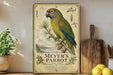 A vintage-style metal plaque featuring a colorful parrot, surrounded by botanical illustrations and text, is displayed on a shelf with a potted plant, a wooden cutting board, and some lemons.