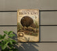 a metal sign with an illustration of a brown kiwi bird, mounted on a wall.