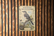 A vintage-style metal sign depicting a Northern Mockingbird, with detailed illustrations and text providing information about the bird.