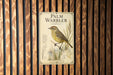 A metal sign with a bird illustration and text is mounted on a wooden wall.