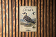 a metal sign with a bird illustration, mounted on a wooden wall.