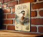 a sign with a red-necked grebe, a type of water bird, depicted in a brick wall setting.