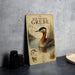 A vintage-style metal plaque with an illustration of a red-necked grebe, a type of water bird, standing in a body of water surrounded by reeds.