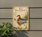 a vintage-style metal sign with illustrations of a red phalarope bird, mounted on a wall next to a plant.