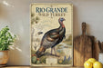 A vintage-style poster of a wild turkey, featuring a detailed illustration of the bird in a natural setting, is displayed on a wall next to a wooden cutting board and some potted plants.