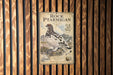a sign with a picture of a bird, likely a pterodactyl, mounted on a wooden wall.
