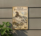 a vintage-style metal plaque with an illustration of a bird, likely a stork, perched on a rock. The plaque is mounted on a wall and is surrounded by greenery, including a plant to the left.