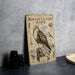a metal plaque with an illustration of a rough-legged hawk, along with various bird species and their habitats.