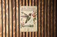 a poster of a Ruby-throated Hummingbird, which is mounted on a wooden wall.