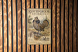a vintage-style poster of a grouse drumming bird, mounted on a wooden wall.
