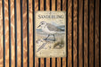 A vintage-style metal sign with illustrations and text, mounted on a wooden wall.