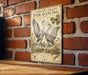 a vintage-style sign with a pair of dancing sandhill cranes against a brick wall.