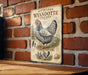 a vintage-style metal sign with a chicken illustration, mounted on a brick wall.