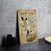 A vintage-style metal sign with a snowy goose illustration and text, placed on a gray countertop next to a stack of black camera lenses.