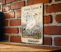 A vintage-style illustration of a snow goose is displayed on a brick wall, with a wooden table below it.