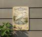 A vintage-style sign depicting a snowy egret wading in a marshy area, with a plant in the foreground.