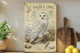 A framed illustration of a snowy owl is displayed on a shelf, accompanied by a wooden cutting board and a potted plant.