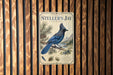 a vintage-style metal sign with a blue jay illustration, mounted on a wooden wall.